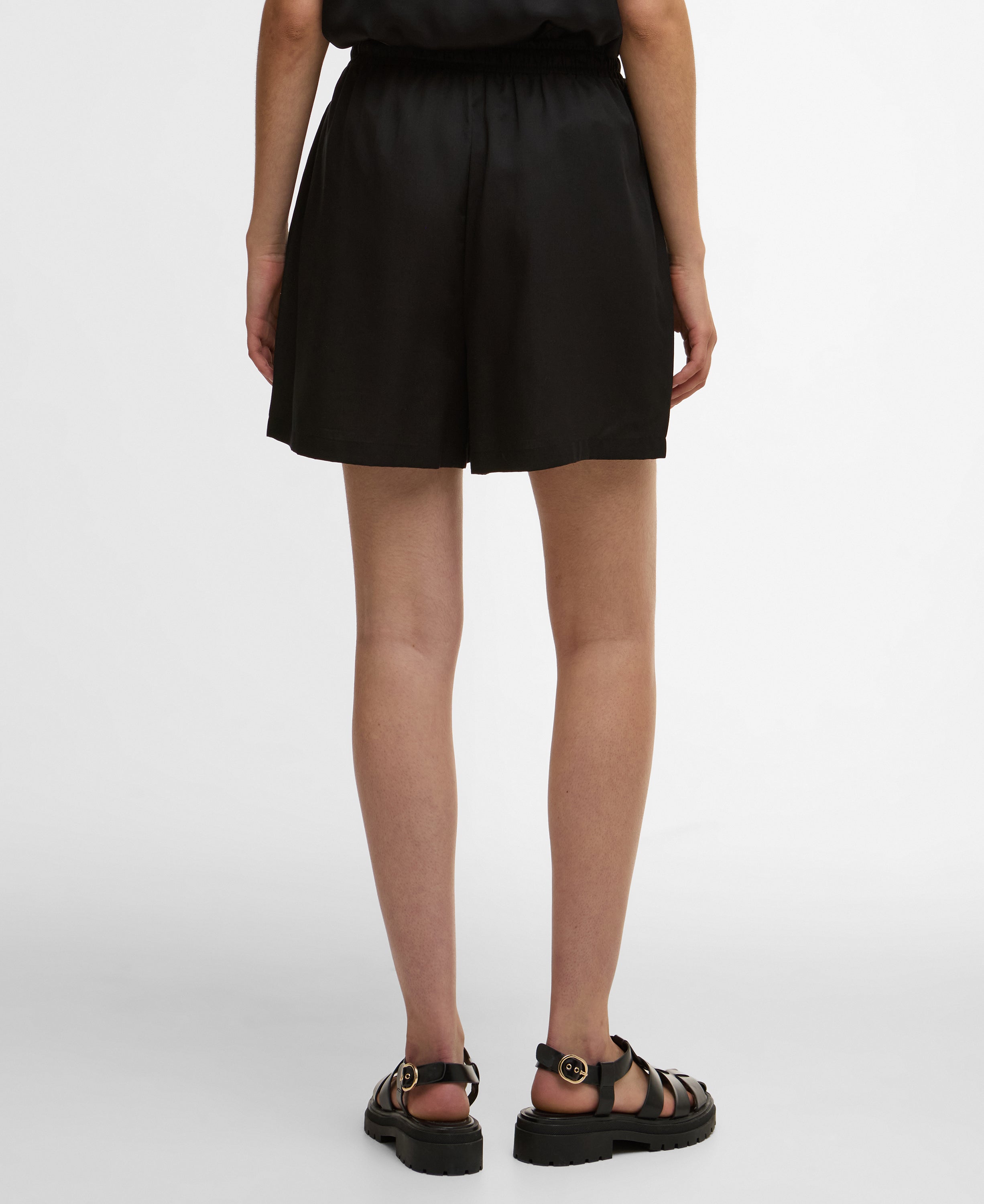 Person wearing black shorts on a white background