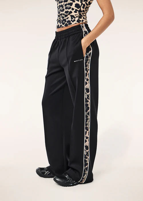 Black pants with leopard print side stripe worn by a person on a white background