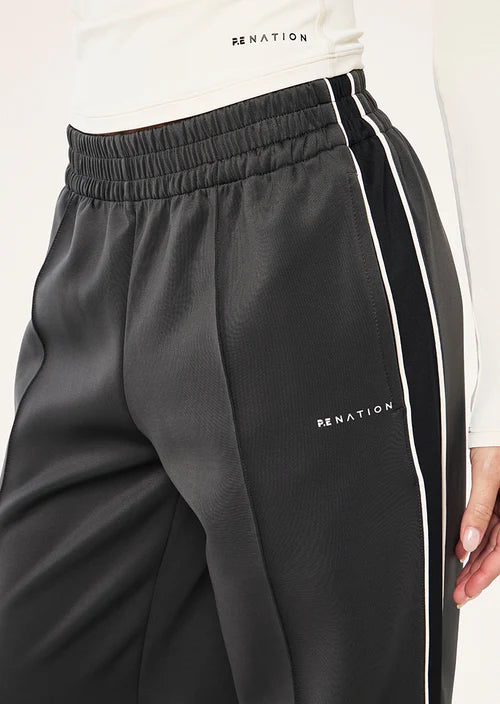 Black pants with white stripes and 'PE NATION' branding on a white background