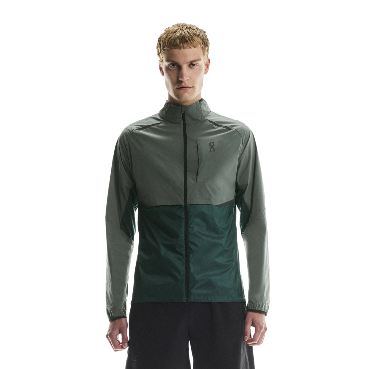 Man wearing a two-tone olive jacket with chest zip pocket on on chest logo with a white background