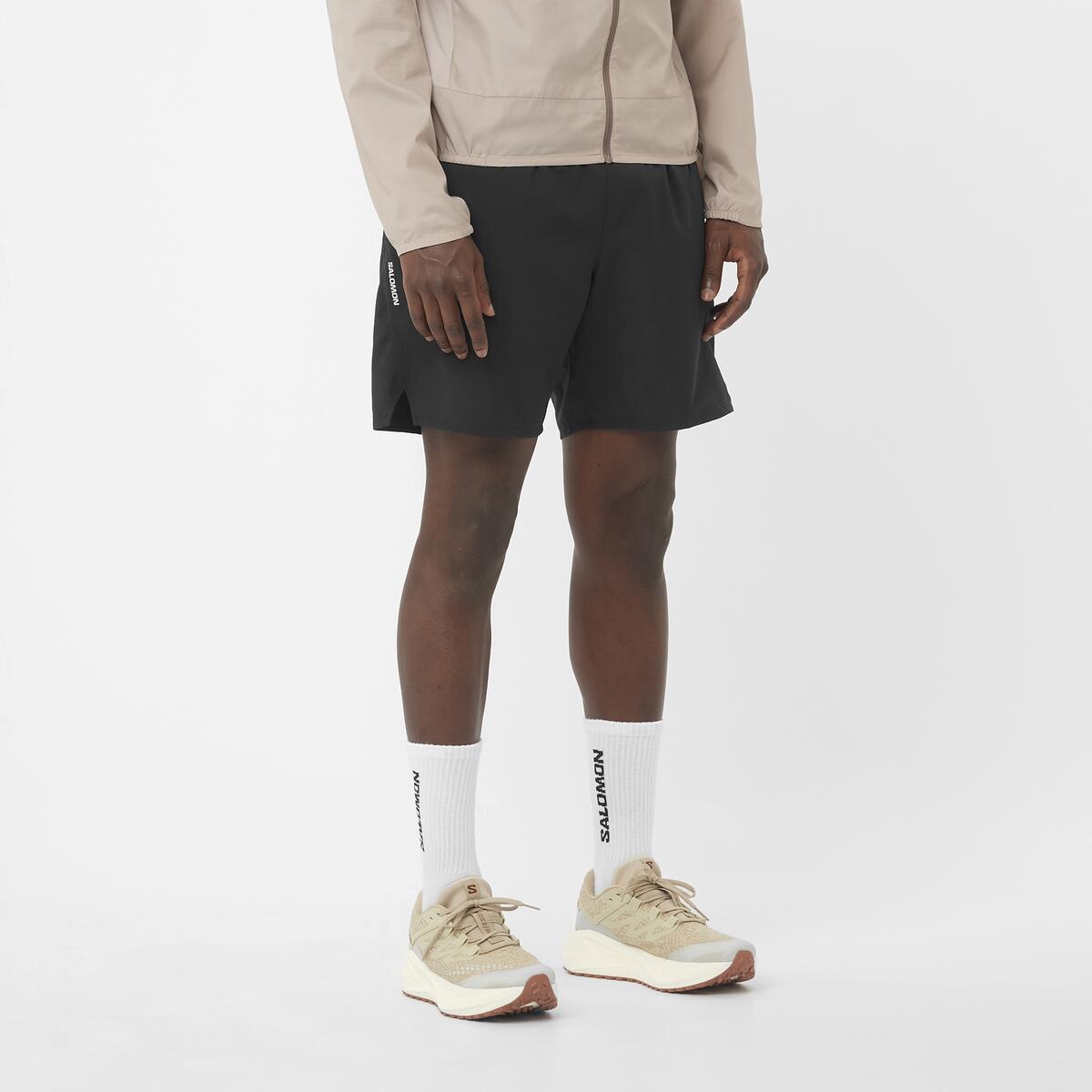 Men's Salomon Deep Black SHKout Core 7" Shorts with reflective salomon logo. styled with matching salomon trainers and salomon t shirt