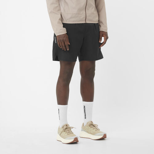 Men's Salomon Deep Black SHKout Core 7" Shorts with reflective salomon logo. styled with matching salomon trainers and salomon t shirt