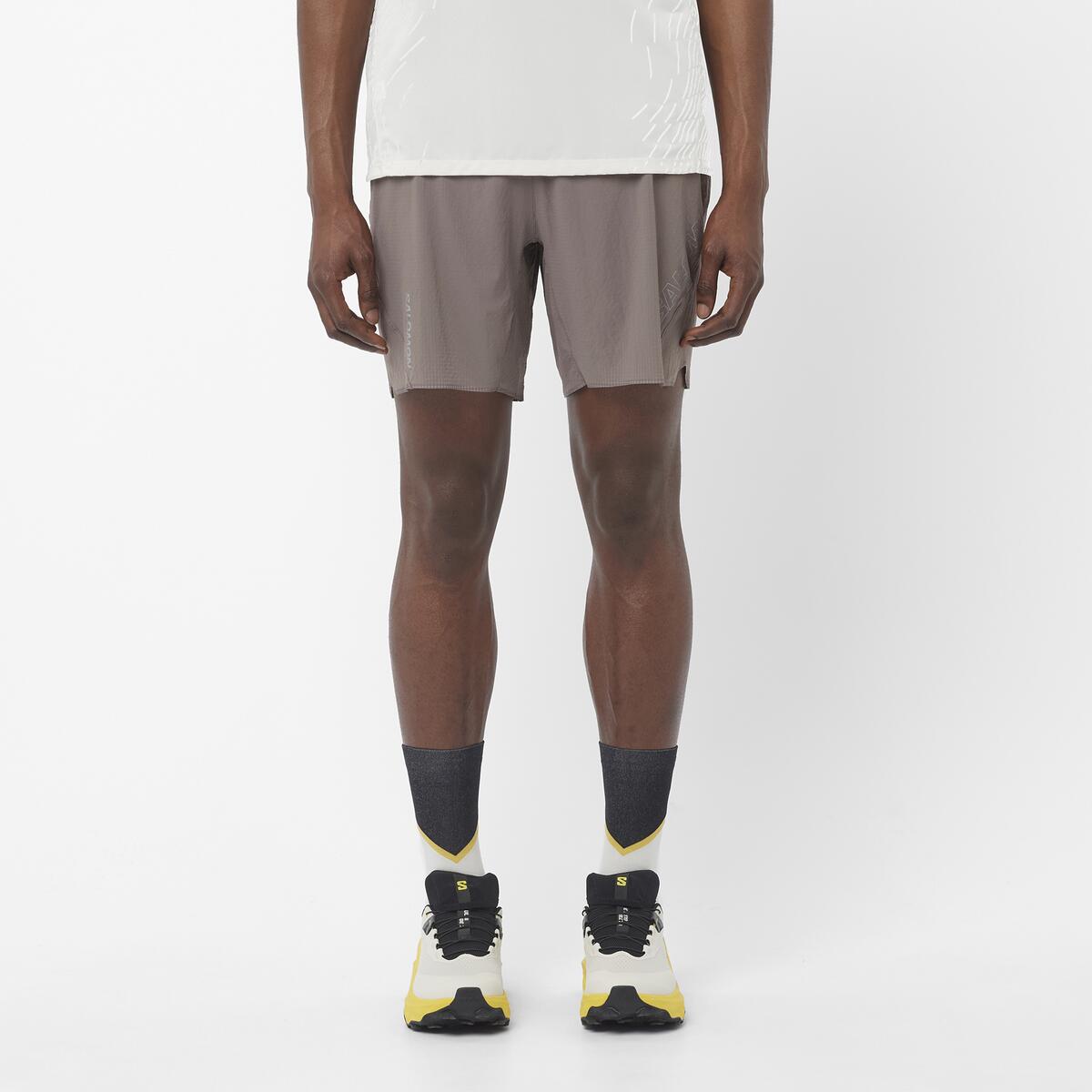 Men's Salomon Iron Sense Aero 7'' Shorts with reflective logos and branding. styled with matching salomon shoes and t shirt 