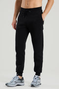 Person wearing red run black jogger pants on a light gray background