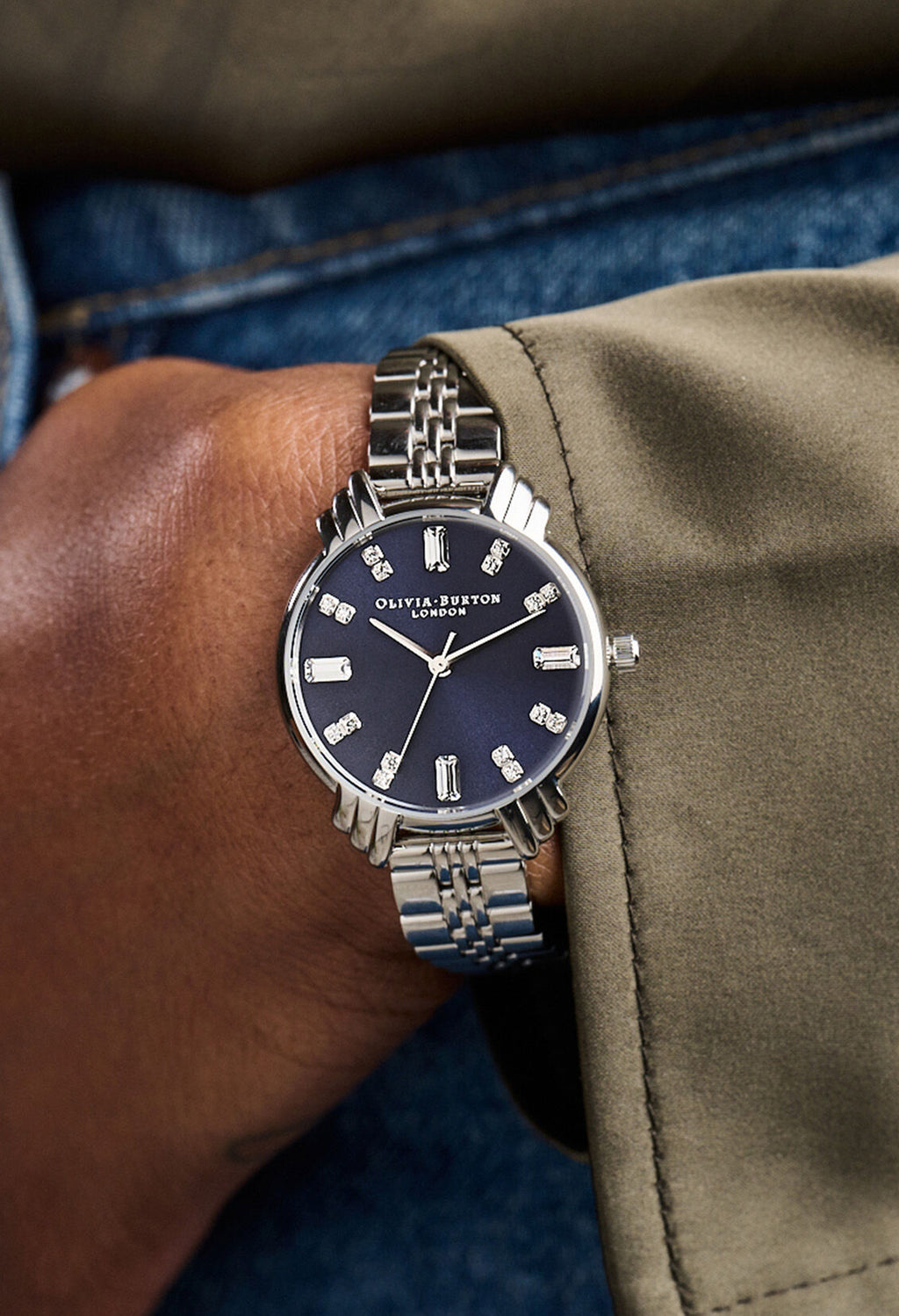 Olivia Burton Art Deco watch on wrist. Navy dial, stainless steel bracelet.