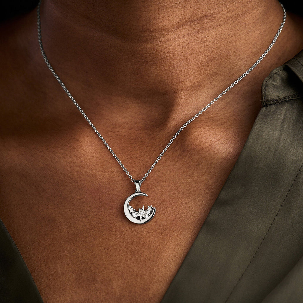 Silver celestial moon necklace displayed on model, showcasing the Olivia Burton pendant's design.