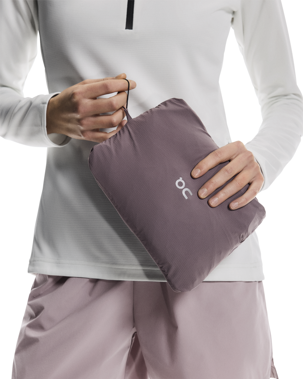 Woman wearing a light gray raincoat on a white background