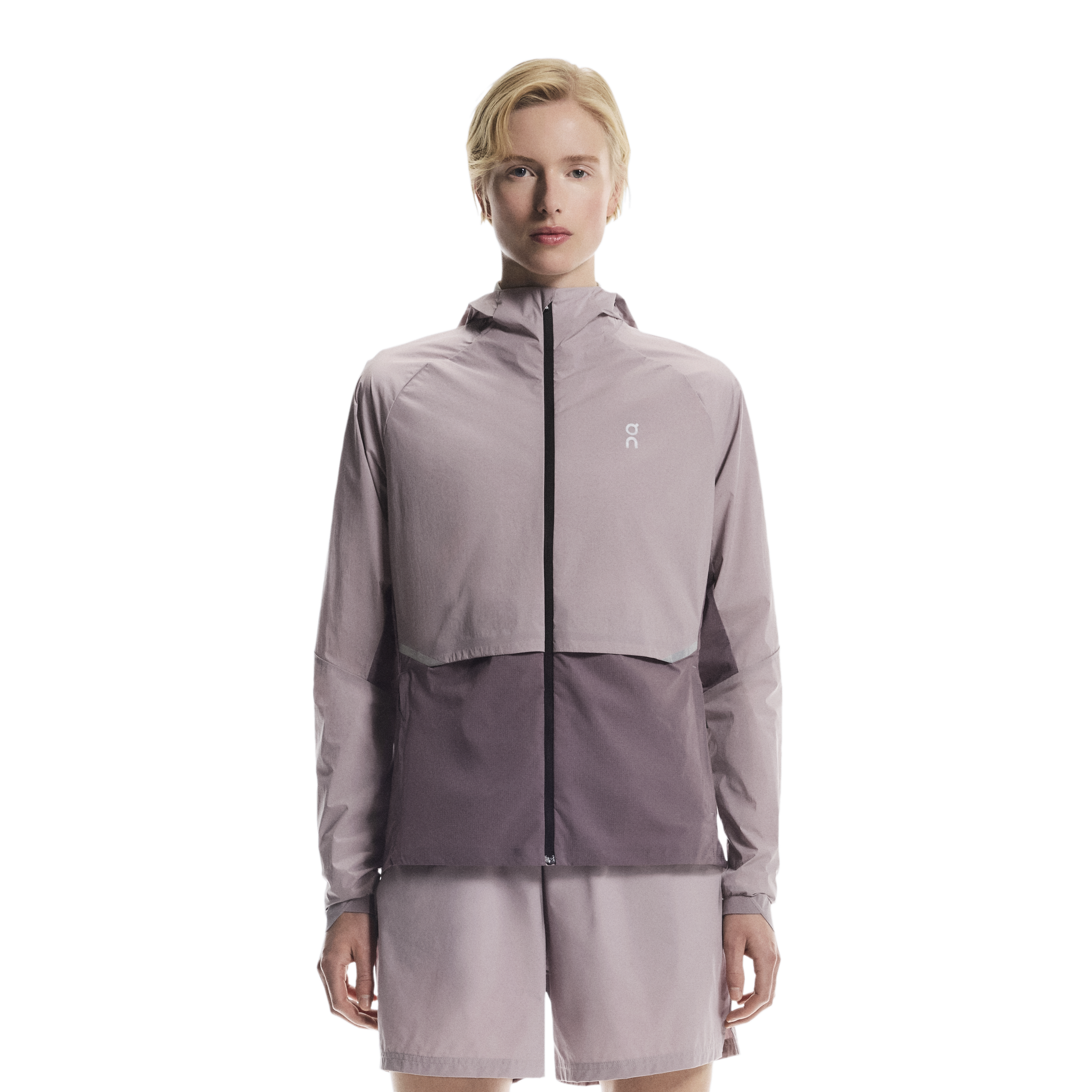 Woman wearing a light purple jacket with a brand logo on a white background