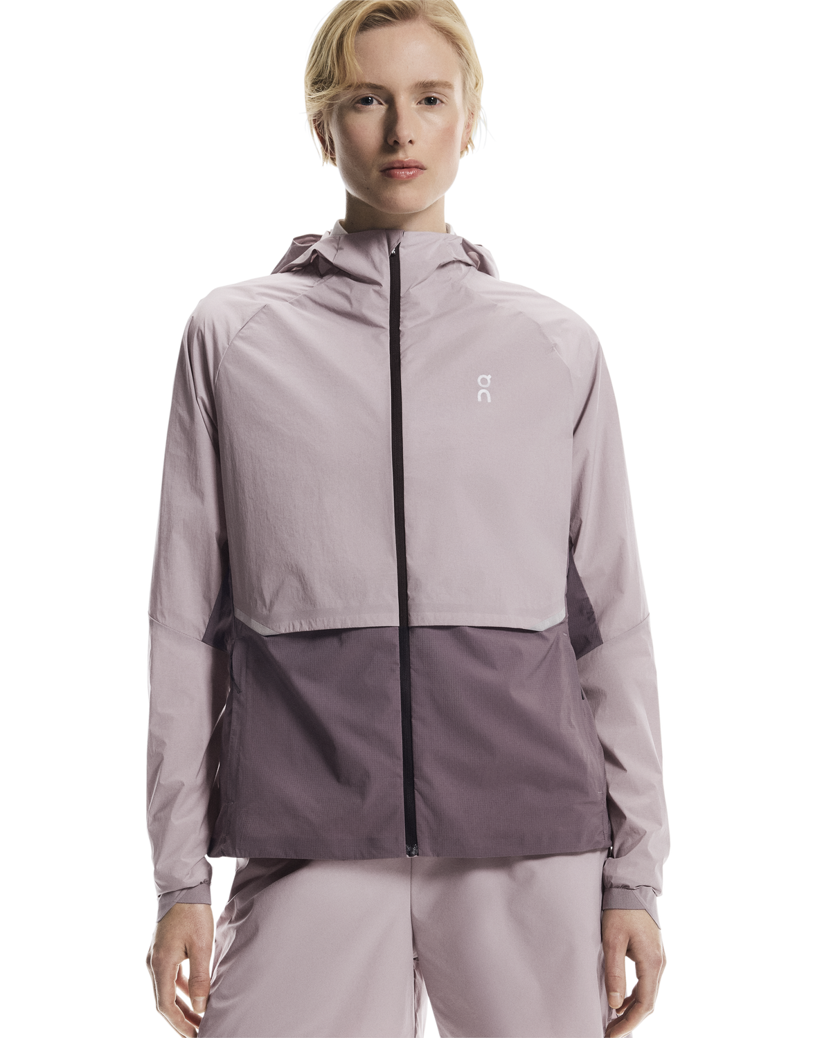 Person wearing a two-tone jacket with a visible brand logo on a white background
