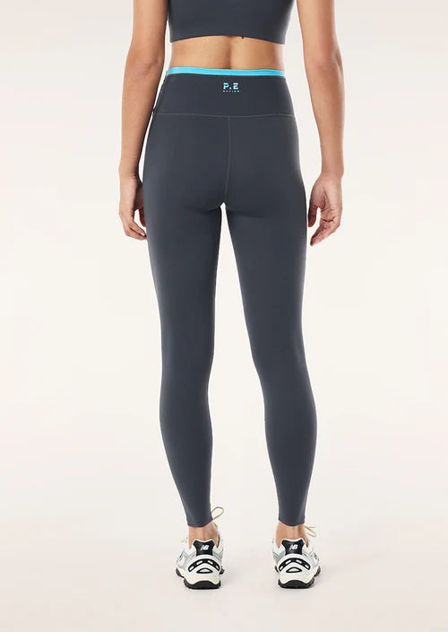 Person wearing dark gray leggings with a visible brand logo on a white background