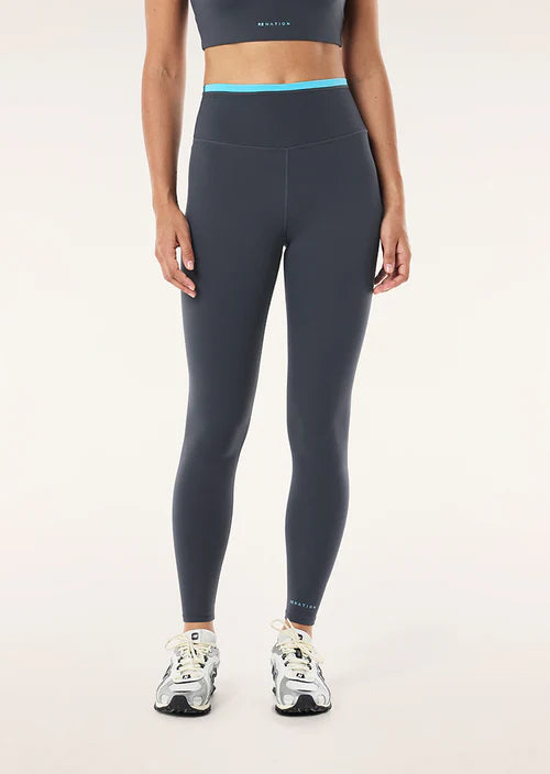 Person wearing dark gray leggings with a light blue waistband on a white background