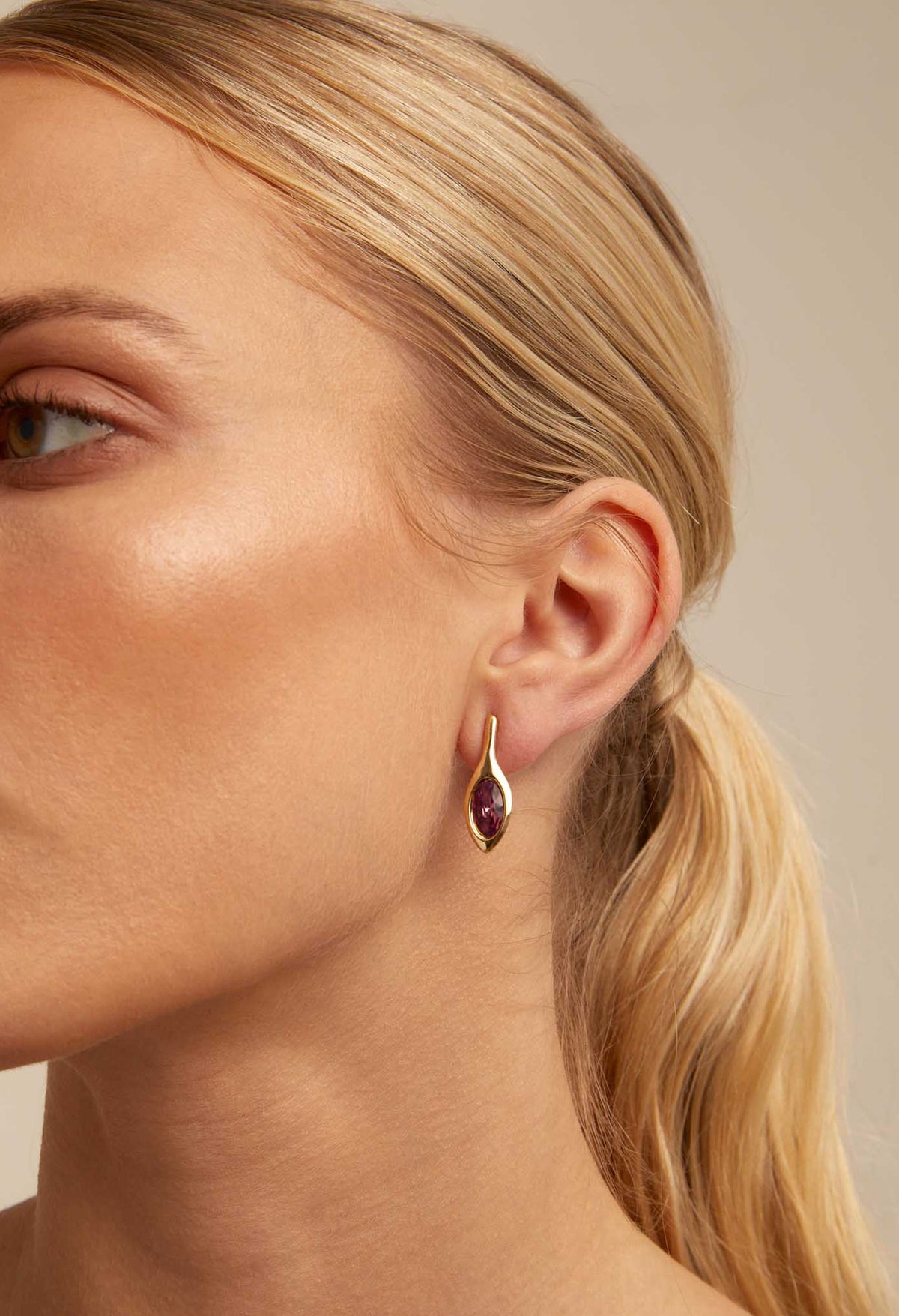 Woman wearing UNOde50 gold-plated blossom earrings. Jewelry fashion shot showing the elegant drop earring design.