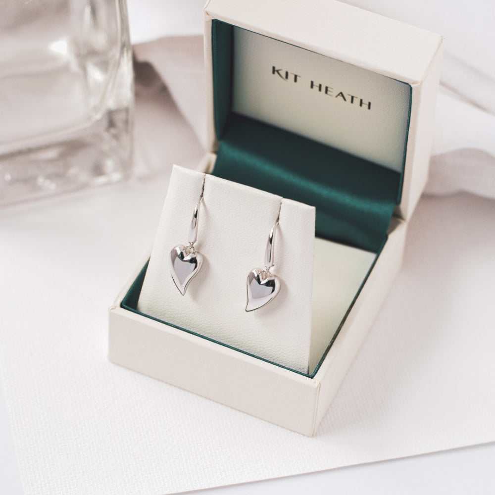 The Desire Cherish Drop Heart Stud Earrings, a silver heart-shaped design from Kit Heath, available at OD’s Jewellers in St Helens