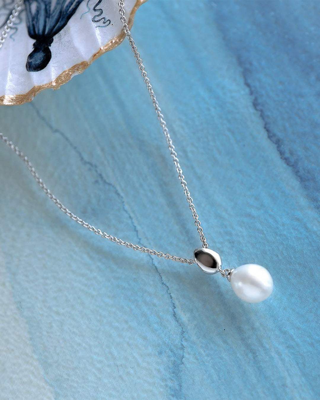 Pebble Pearl Necklace on a styled background