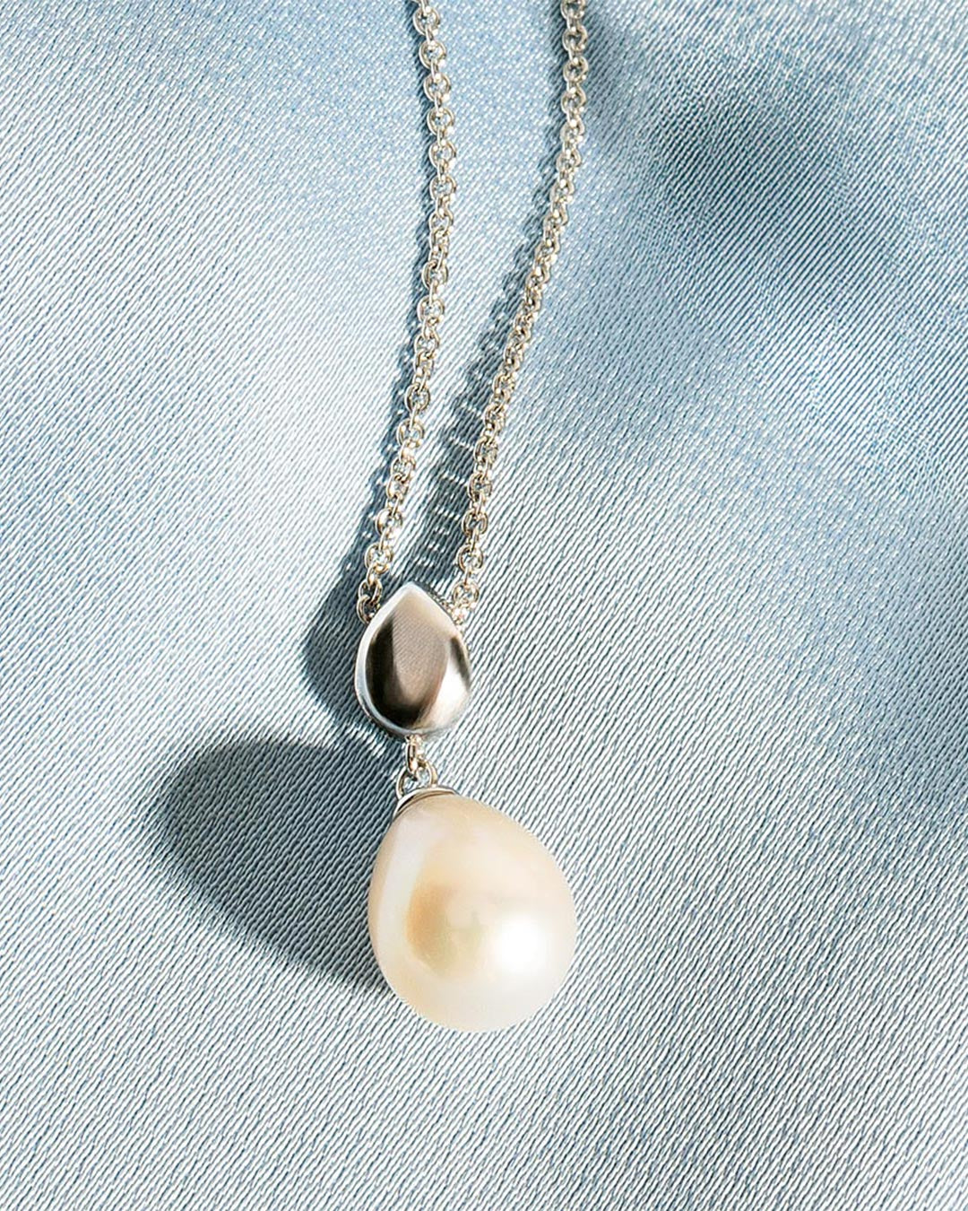 Pebble Pearl Necklace on a styled background