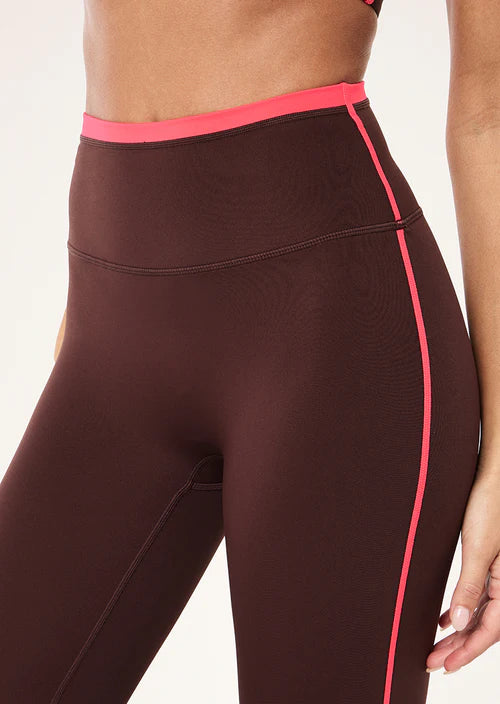 Brown leggings with pink accents on a white background