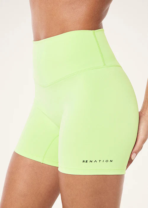 Neon green shorts with 'P.E Nation' branding on a white background