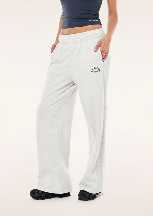 Person wearing light grey P.E nation sweatpants with a logo on a light pink background