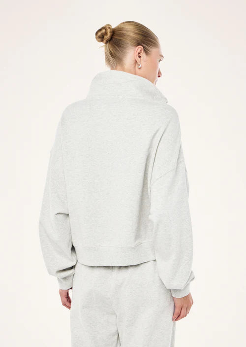 Person wearing a light gray fleece jacket and pants on a white background