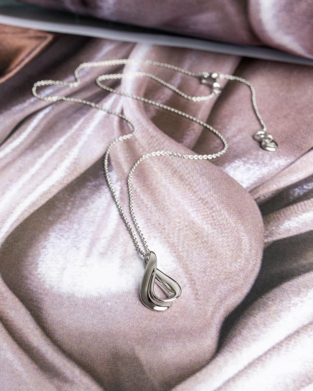 Serenity Loop Dainty Necklace on a styled background