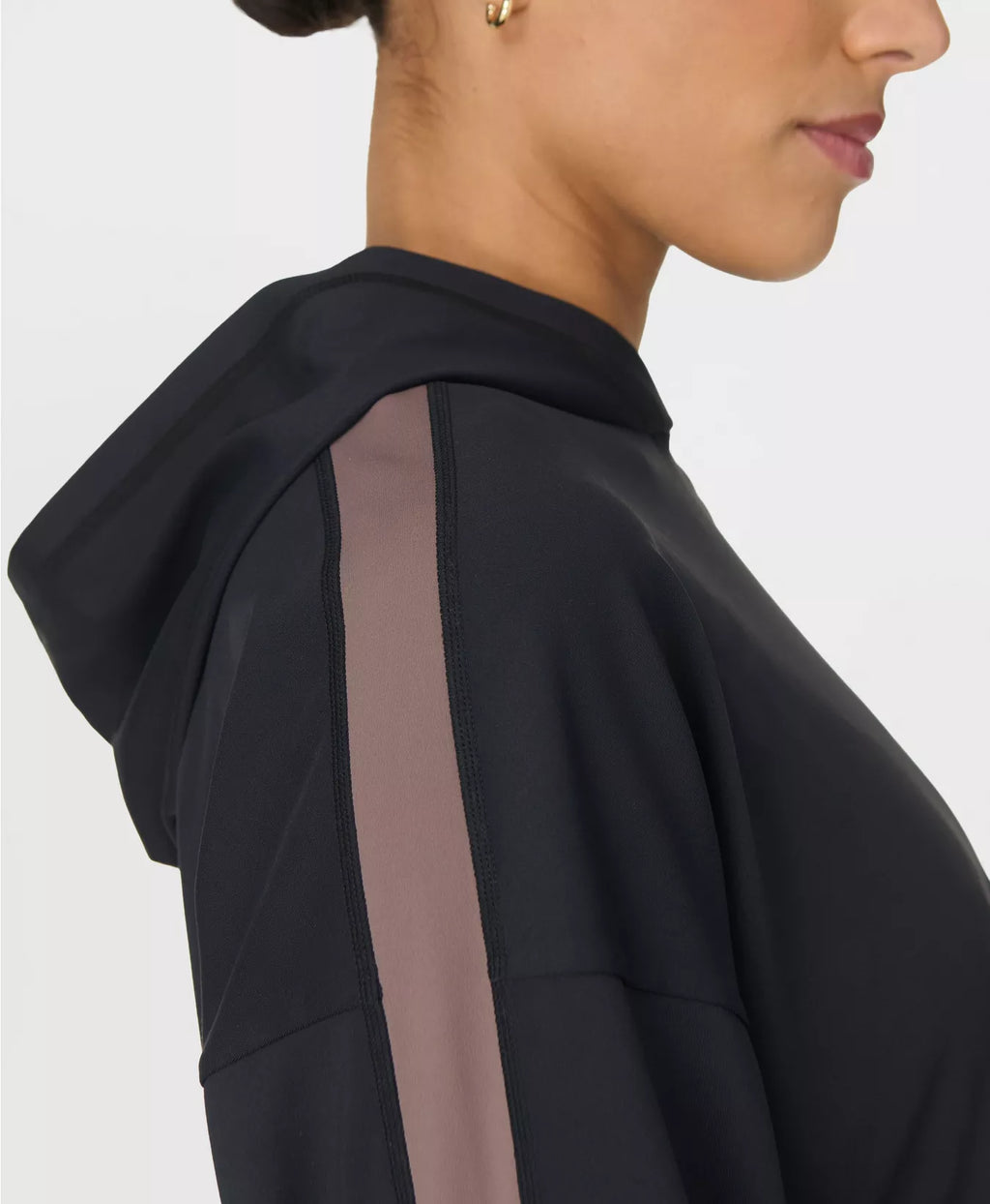 Close-up of a person wearing a black hoodie with a white background