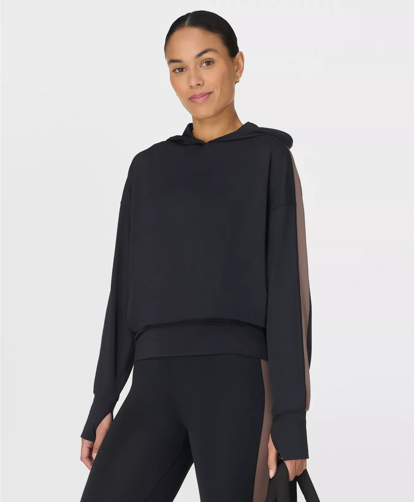 Woman wearing a black hoodie with sheer sleeves on a white background