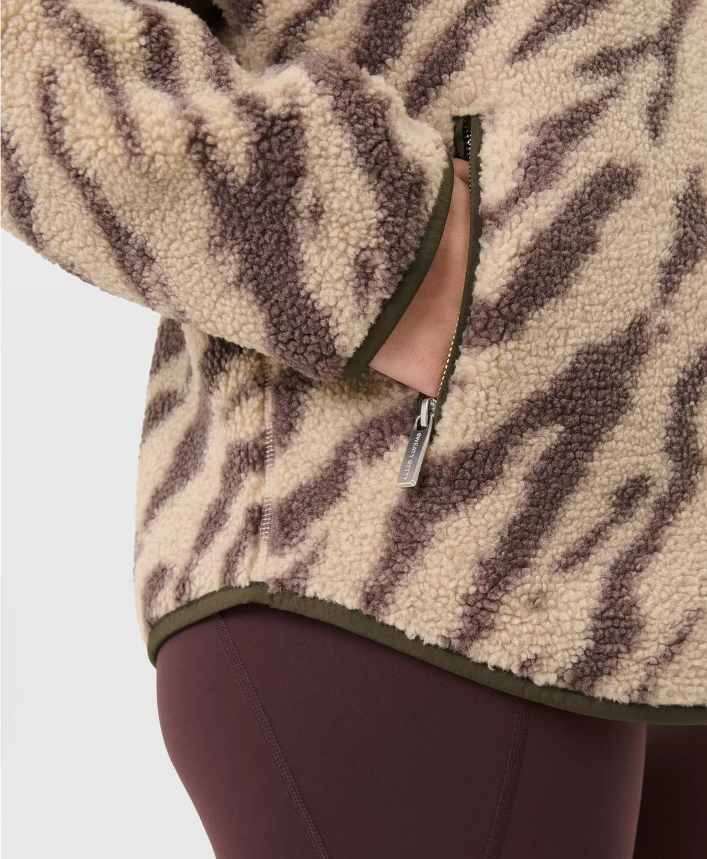 Close-up of a person wearing a patterned fleece jacket with a visible brand logo.