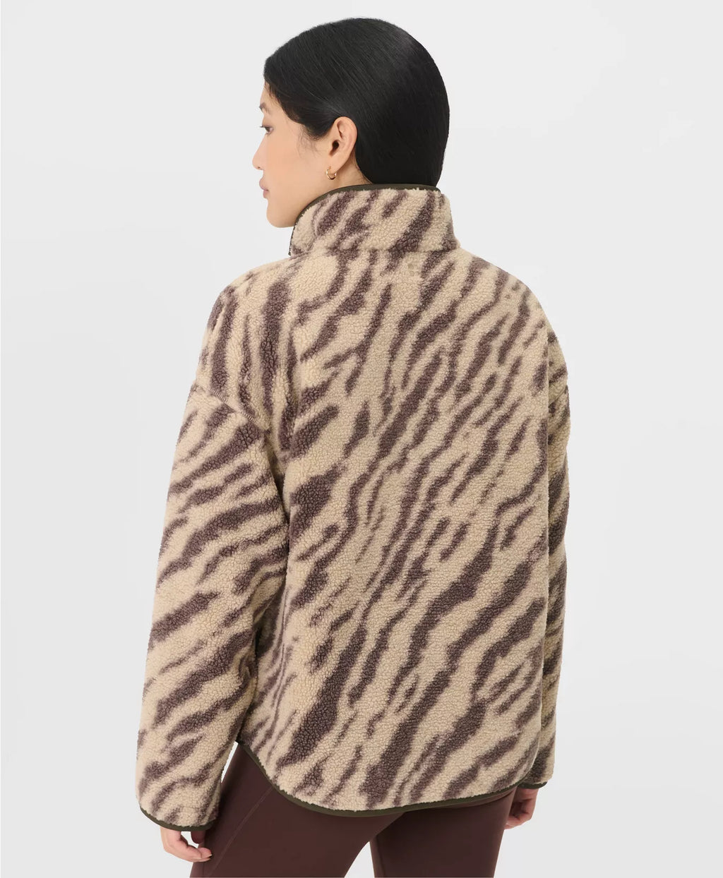 Person wearing a zebra print jacket on a plain background