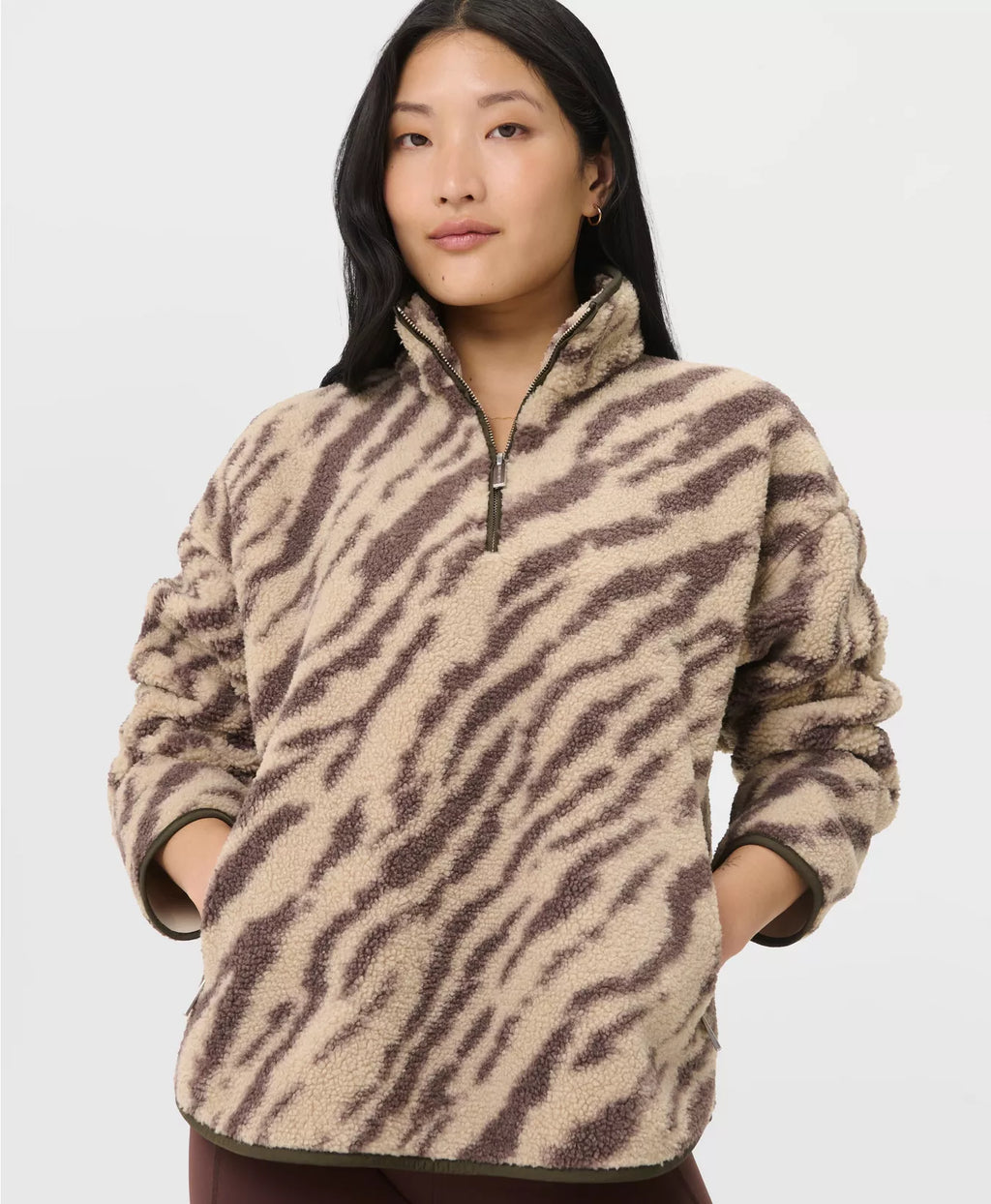 Woman wearing a zebra print fleece pullover against a white background