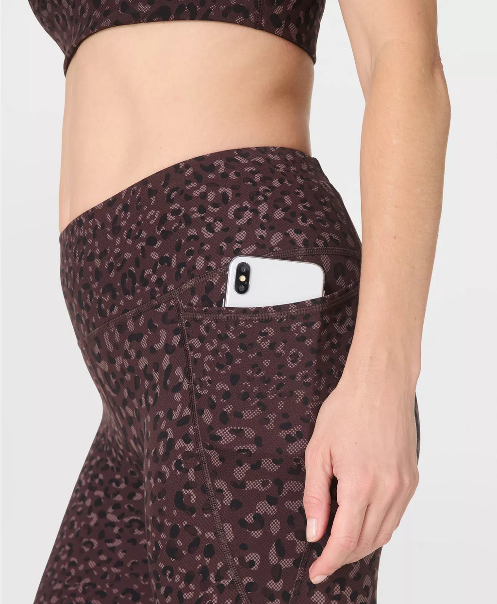 Leopard print leggings with a pocket on a plain background