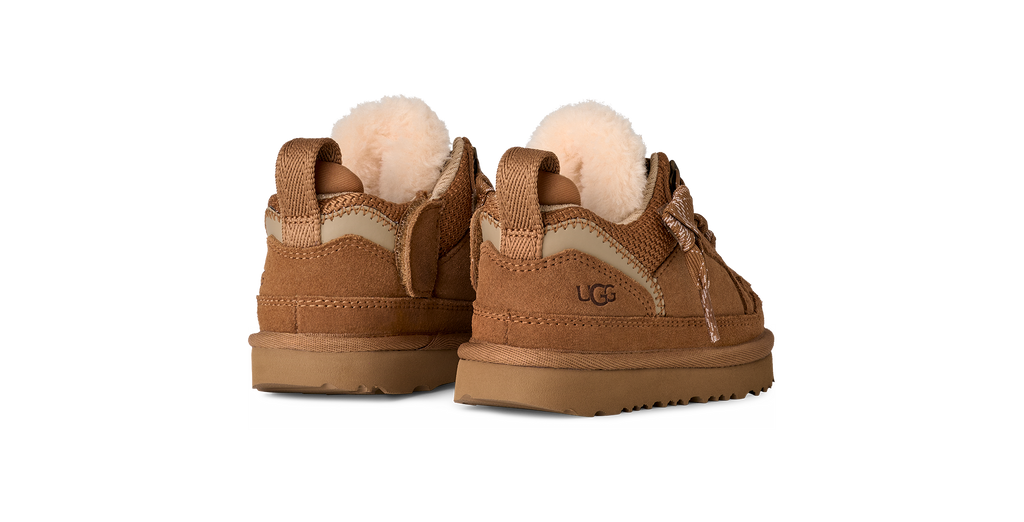 Pair of brown UGG boots with pom-poms on a white background