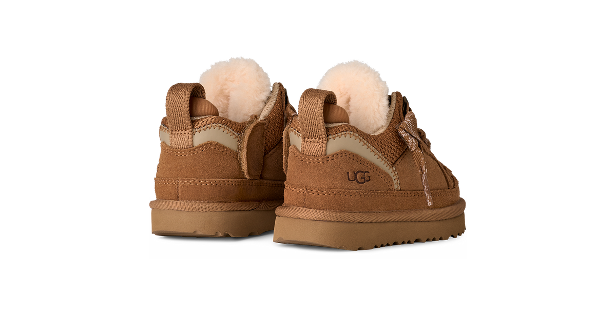 Pair of brown UGG boots with pom-poms on a white background