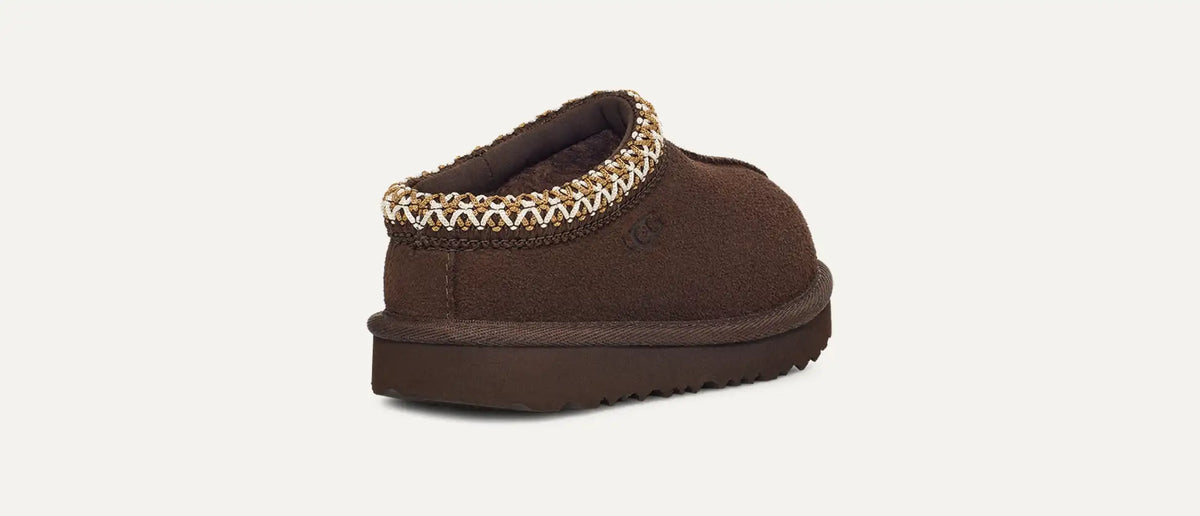 Brown slipper with decorative trim on a white background