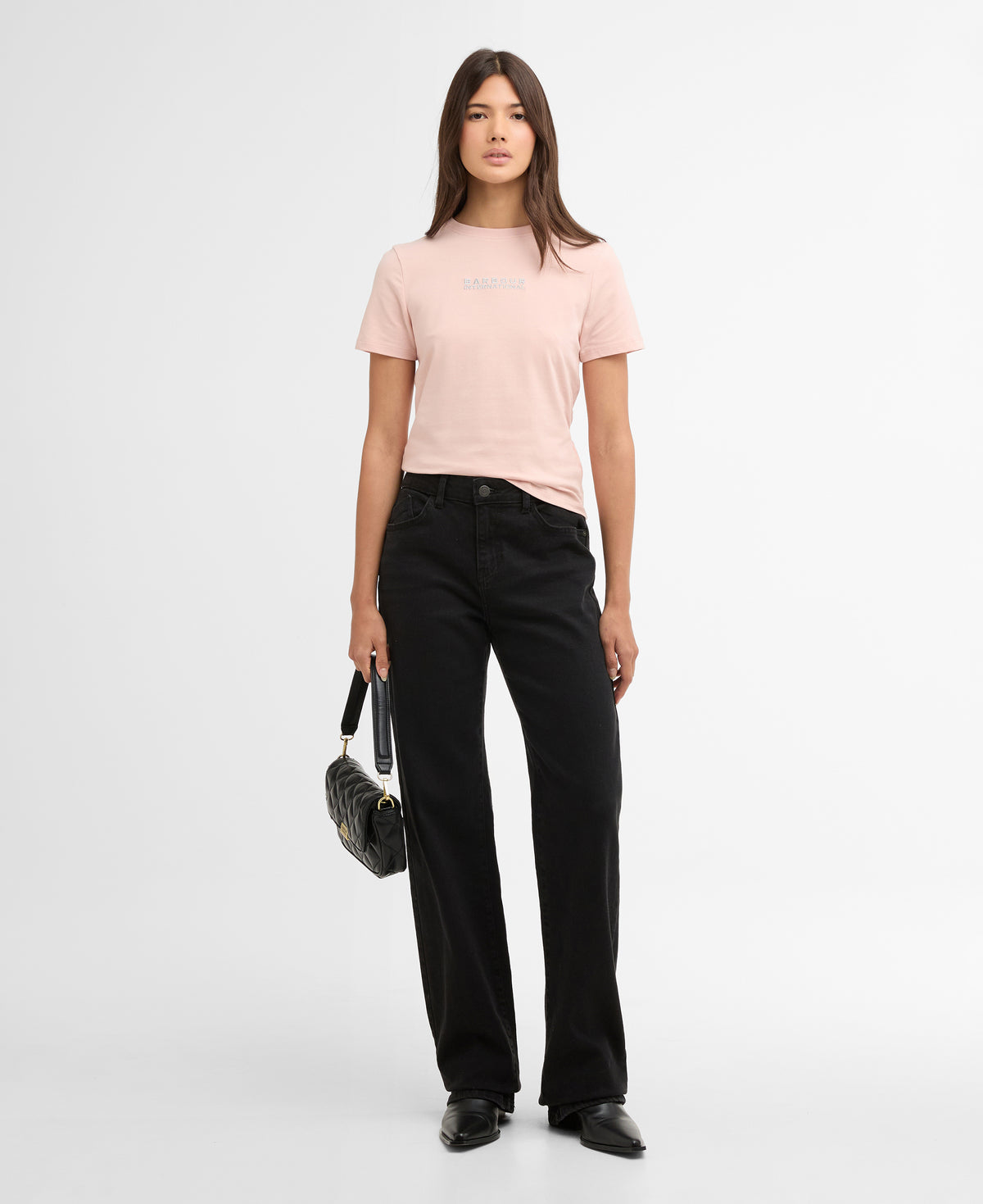 Woman wearing a pink top and black pants on a white background