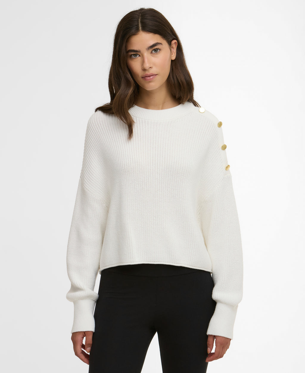 Woman wearing a white sweater with gold buttons on a white background