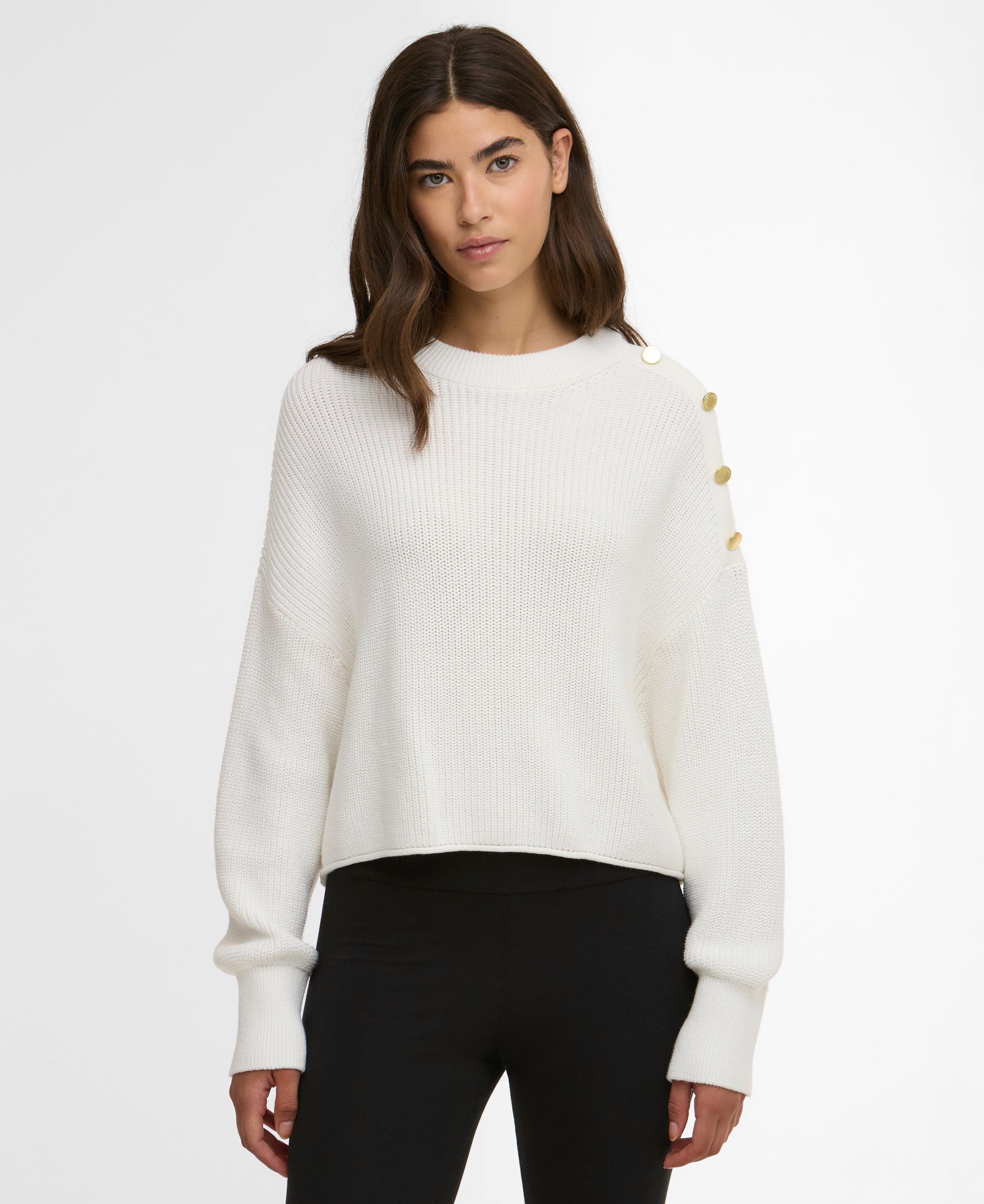 Woman wearing a white sweater with gold buttons on a white background
