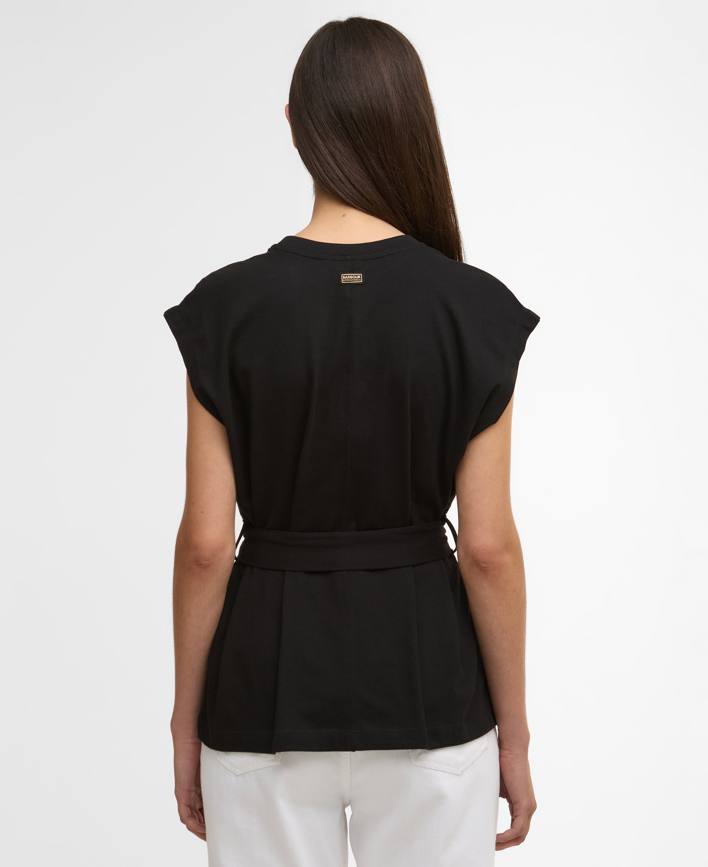 Black sleeveless top worn by a person on a white background