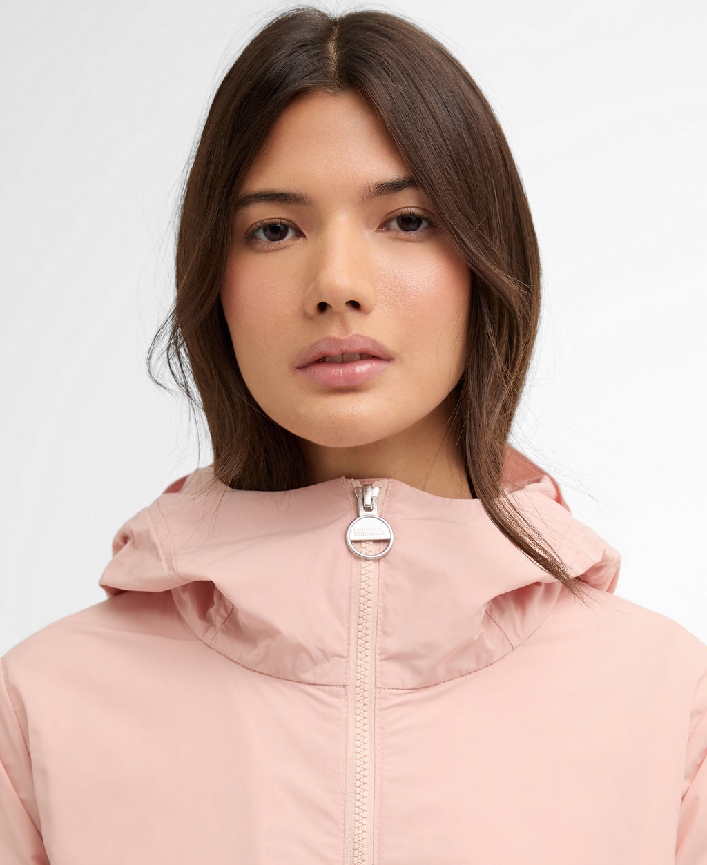Person wearing a pink hooded jacket with a white background