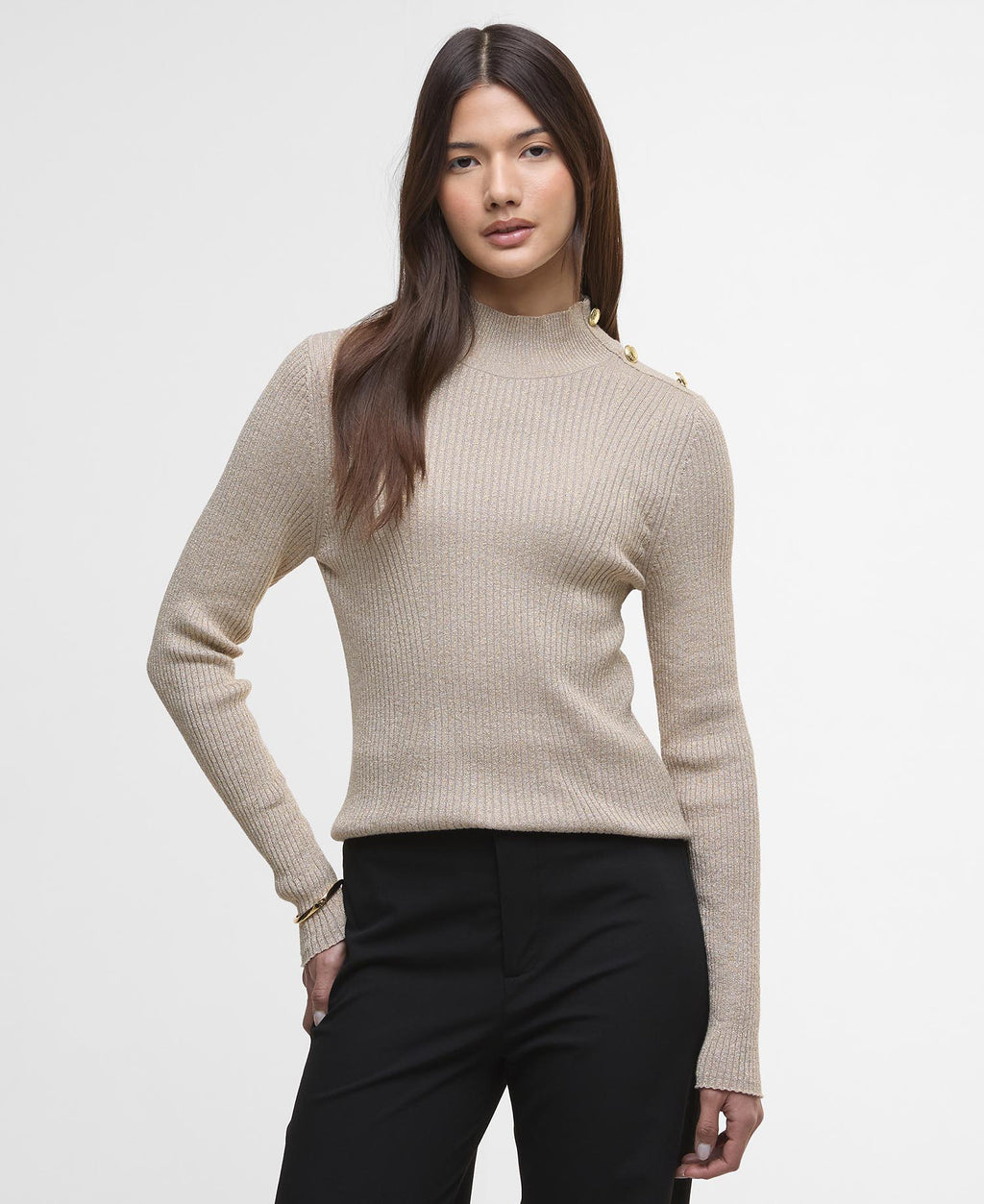 Woman wearing a beige ribbed sweater with a plain background