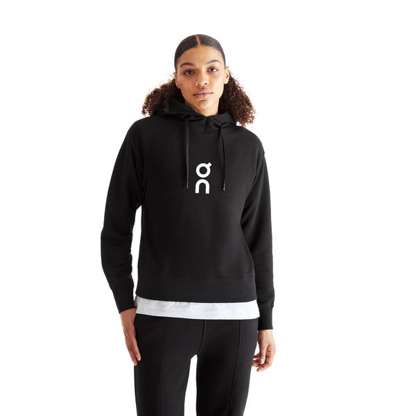 person wearing a black On Running Club Hoodie with white contrast logo against a white background