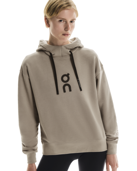 Person wearing a beige hoodie with a logo on a white background