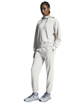 A woman standing, wearing a silver hoodie and matching silver pants with a relaxed fit, designed for running or leisure activities.