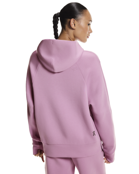 Person wearing a pink hoodie and pants on a white background