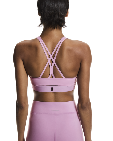 Person wearing a pink sports bra and leggings on a white background