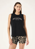 Woman wearing a black sleeveless top with 'PE Nation' text and leopard print shorts on a white background