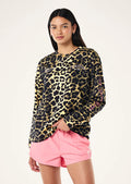 Person wearing a leopard print long-sleeve shirt and pink shorts on a white background