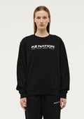 Model wearing P.E Nation Black round neck Sweater with a white background