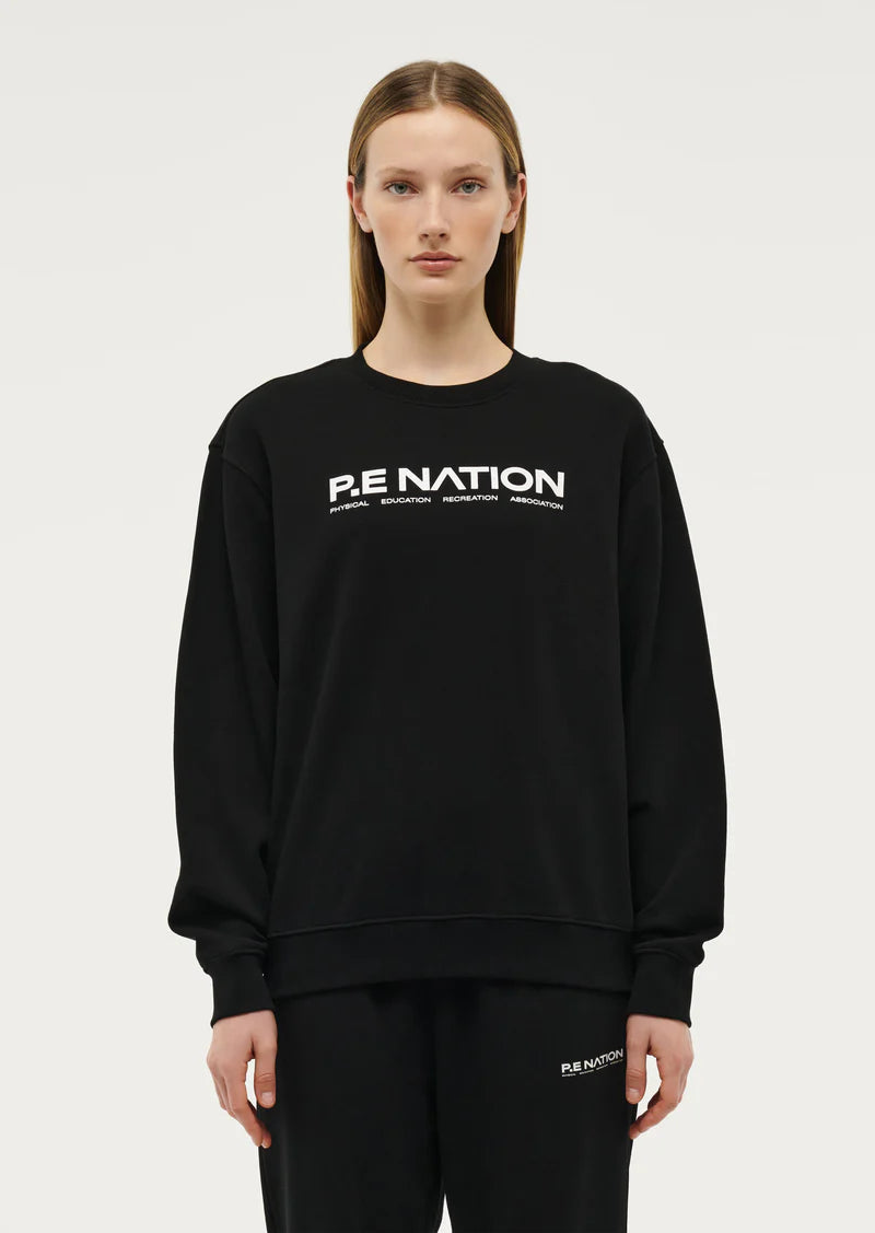 Model wearing P.E Nation Black round neck Sweater with a white background