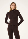 Woman wearing a brown activewear fitted jacket on a white background