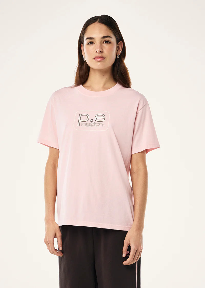 Person wearing a pink t-shirt with 'p.e. nation' logo on a white background